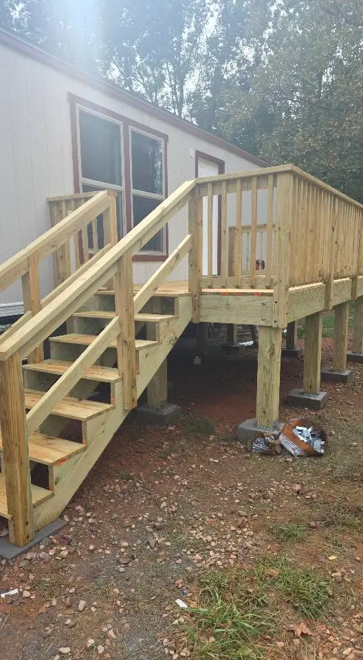 Custom elevated porch platform with steps and full wood railing