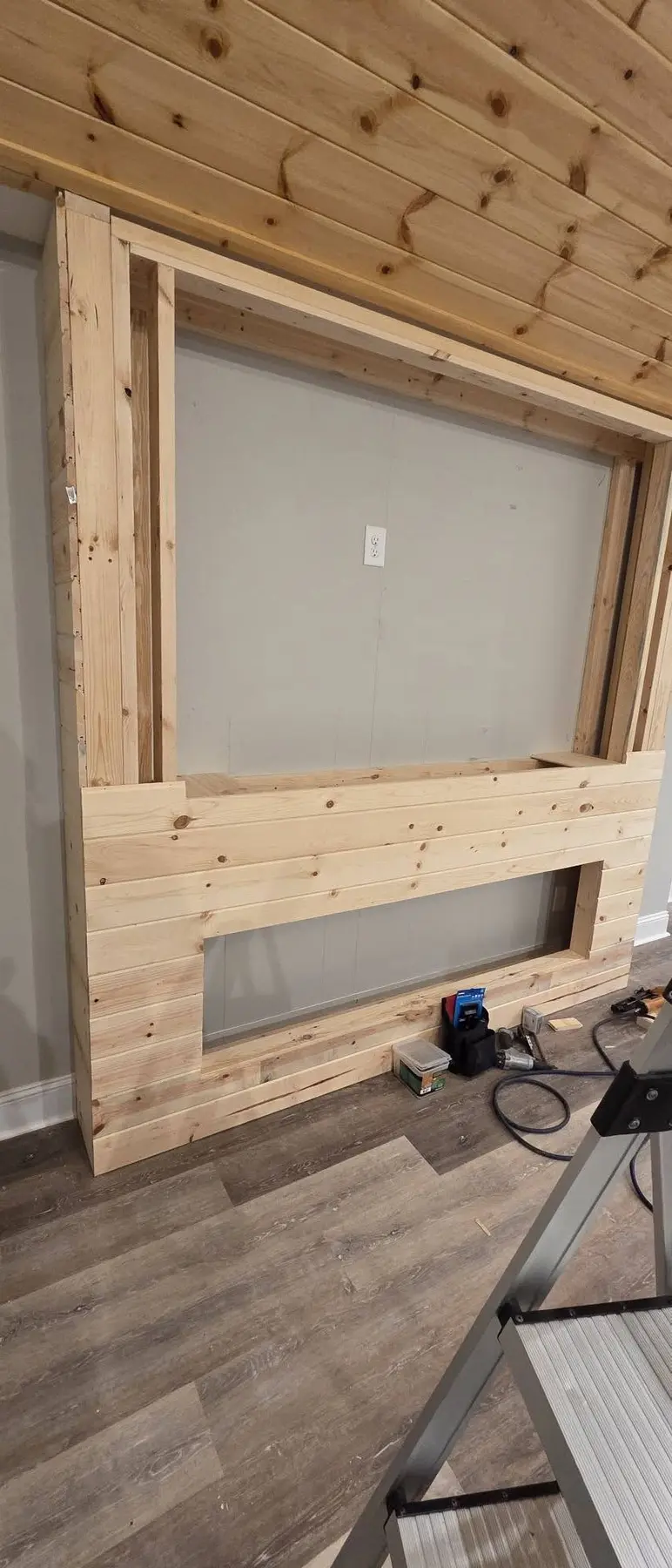Wood panel installation around the framed fireplace opening